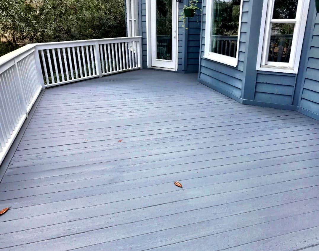 Refinished blue-gray wood deck with a clean white railing